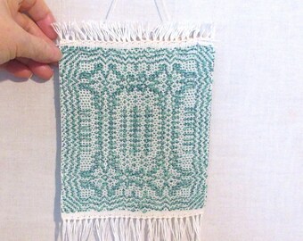 Green and white hand woven tiny tapestry wall hanging room decor. Small weaving in an overshot pattern is  6" by 14" overall length