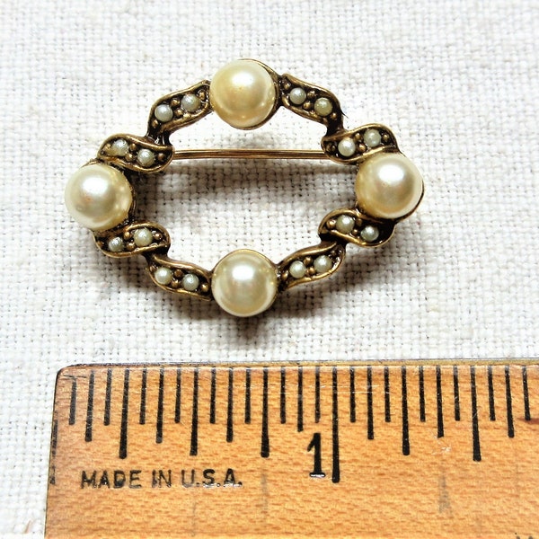 Vintage pearl circle brooch has faux pearls, About 1" across. Good used condition. One pearl has been re glued.