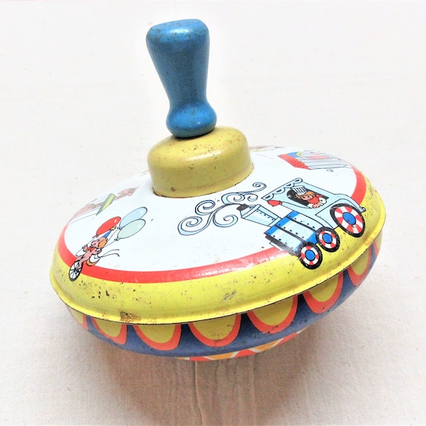 Vintage 1960s Ohio Art tin spinning top toy with a wood handle. About 5" tall and 5.5" diameter. A little sticky but spins most of the time.