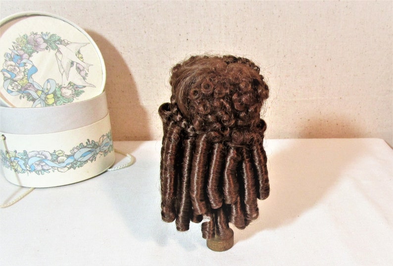 Reddish brown synthetic hair with sausage spiral or ringlet curls and braids. Doll wig Made in Korea Kemper Originals doll wig size 89