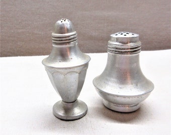 Vintage salt, pepper shakers. Mismatched pair of aluminum shakers. Both weighted in the bottom,