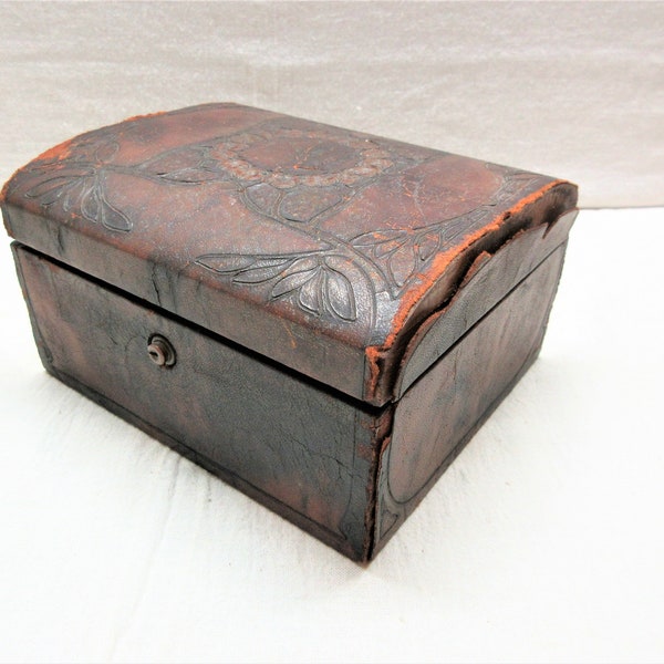 Antique tooled leather covered jewelry box is 6" long, 3.5" tall and 5.75" deep. Leather is deteriorating, the box is solid. No key