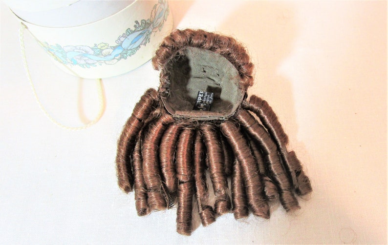 Reddish brown synthetic hair with sausage spiral or ringlet curls and braids. Doll wig Made in Korea Kemper Originals doll wig size 89