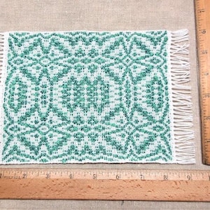 Green hand woven 1/6 scale dollhouse rug: Maltese Cross overshot pattern.