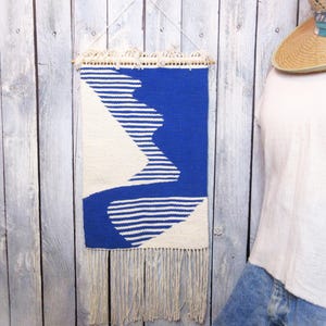 Geometric wall decor. Handwoven wall hanging textile fiber art is 30&quot; total length by 12&quot; wide. Natural white and blue cotton yarn