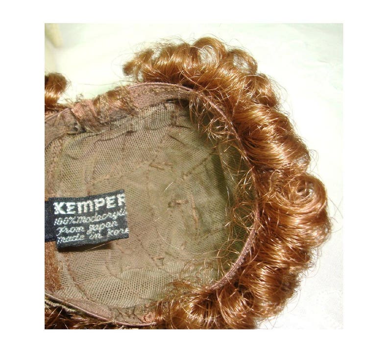 Reddish brown synthetic hair with sausage spiral or ringlet curls and braids. Doll wig Made in Korea Kemper Originals doll wig size 89
