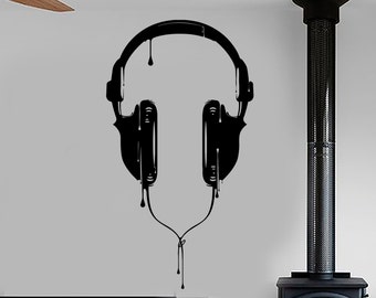 May include: Black and white silhouette of headphones dripping with paint on a white wall. The headphones are in the center of the image. There is a wood-burning stove on the right side of the image.