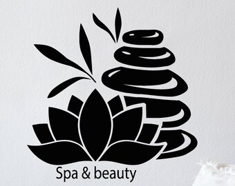 May include: Black and white silhouette of a lotus flower and stacked stones with the text "Spa & beauty" on a white wall.