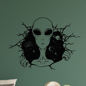 May include: Black and white alien head peeking out of a cracked wall with stars and planets in the background. The alien has large eyes and a pointed head.