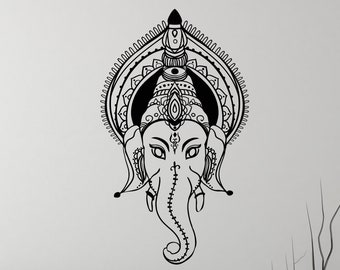 May include: Black and white line art wall decal of the Hindu deity Ganesha, with an intricate mandala design behind the elephant head. The decal is displayed on a white wall above a bed with gray bedding.