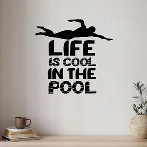 May include: Black and white wall decal with a silhouette of a swimmer and the text "Life is cool in the pool".