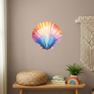 May include: A large, colorful seashell wall art piece. The shell is painted with a gradient of colors, including orange, yellow, pink, purple, and blue. The artwork is mounted on a neutral-toned wall, creating a vibrant focal point.