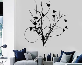 May include: Black and white silhouette wall decal of a stylized tree with branches and leaves. The decal is shown on a white wall in a living room setting.