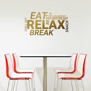 May include: A white table with a stainless steel base and four red and white chairs. The wall behind the table has a gold word cloud with the words "Eat", "Relax", "Break", "Chill Out", "Rest", "Talk", "Collaborate", "Refresh", and "Snack".