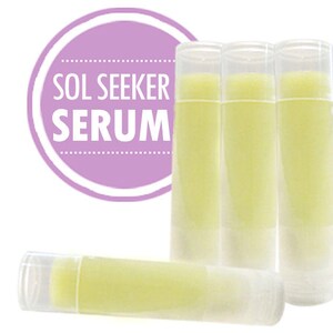 May include: Four clear tubes of yellow lip balm with the text "SOL SEEKER SERUM" on a purple circle.