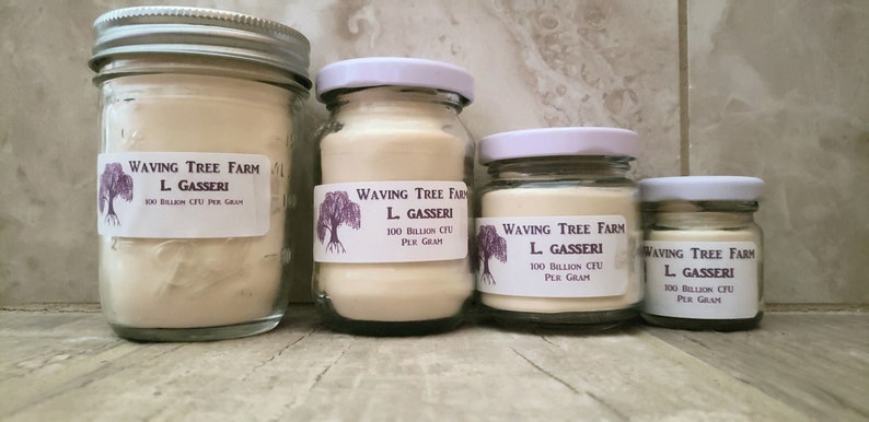 May include: Four glass jars with white lids containing a white powder. The jars are labeled "Waving Tree Farm L. Gasseri 100 Billion CFU Per Gram".