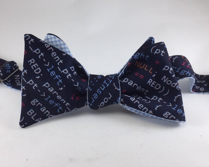 May include: A blue bow tie with a white and blue checkered pattern on the back. The front of the bow tie features code printed in blue, red, and pink.
