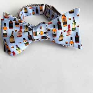 Whisky Bow tie - made to order, reversible bow tie has colorful whiskey bottles printed on light blue cotton.