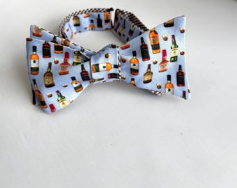 Whisky Bow tie - made to order, reversible bow tie has colorful whiskey bottles printed on light blue cotton.