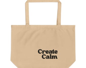 May include: A beige tote bag with two shoulder straps and the text Create Calm printed in black on the lower right side. The bag features a rectangular body with a flat bottom and a simple, functional design for carrying various personal items.