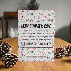 Könnte beinhalten: Eine weiße GDPR-Einverständniskarte mit einem Muster aus roten und grünen Umschlägen und Kästchen. Die Karte enthält den Text "GDPR Consent Card" und Anweisungen zur Anmeldung für zukünftige Karten. Kiefernzapfen befinden sich im Vordergrund.