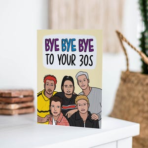May include: A greeting card with a cartoon illustration of five people with the text "Bye Bye Bye to Your 30s" on a yellow background.