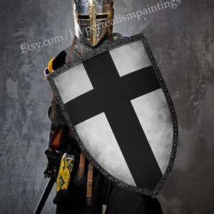 May include: A medieval knight in full armor, including a helmet, chainmail, and a shield with a black cross on a white background. The image includes the text "Hand made, with 3 layers for ultimate strength" and the Etsy shop URL.