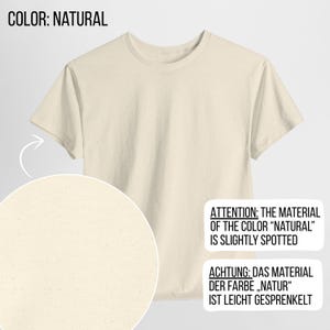 May include: A short-sleeved t-shirt in a natural off-white color with a subtle speckled texture throughout the fabric. The image includes text stating COLOR: NATURAL and ATTENTION: THE MATERIAL OF THE COLOR "NATURAL" IS SLIGHTLY SPOTTED.