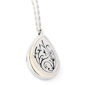May include: A silver teardrop-shaped essential oil diffuser necklace with a delicate chain. The pendant features a black floral design.