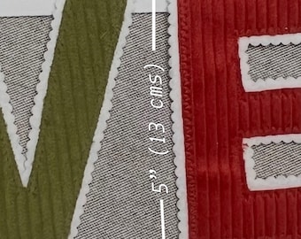 May include: A decorative fabric letter patch featuring a textured olive green corduroy surface with a white scalloped stitched border. A white vertical line indicates a height measurement of 5 inches (13 cms) next to a red corduroy letter E.