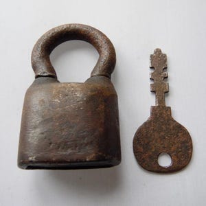 May include: A rusty padlock with a key. The padlock is made of metal and has a square shape. The key is also made of metal and has a simple design.
