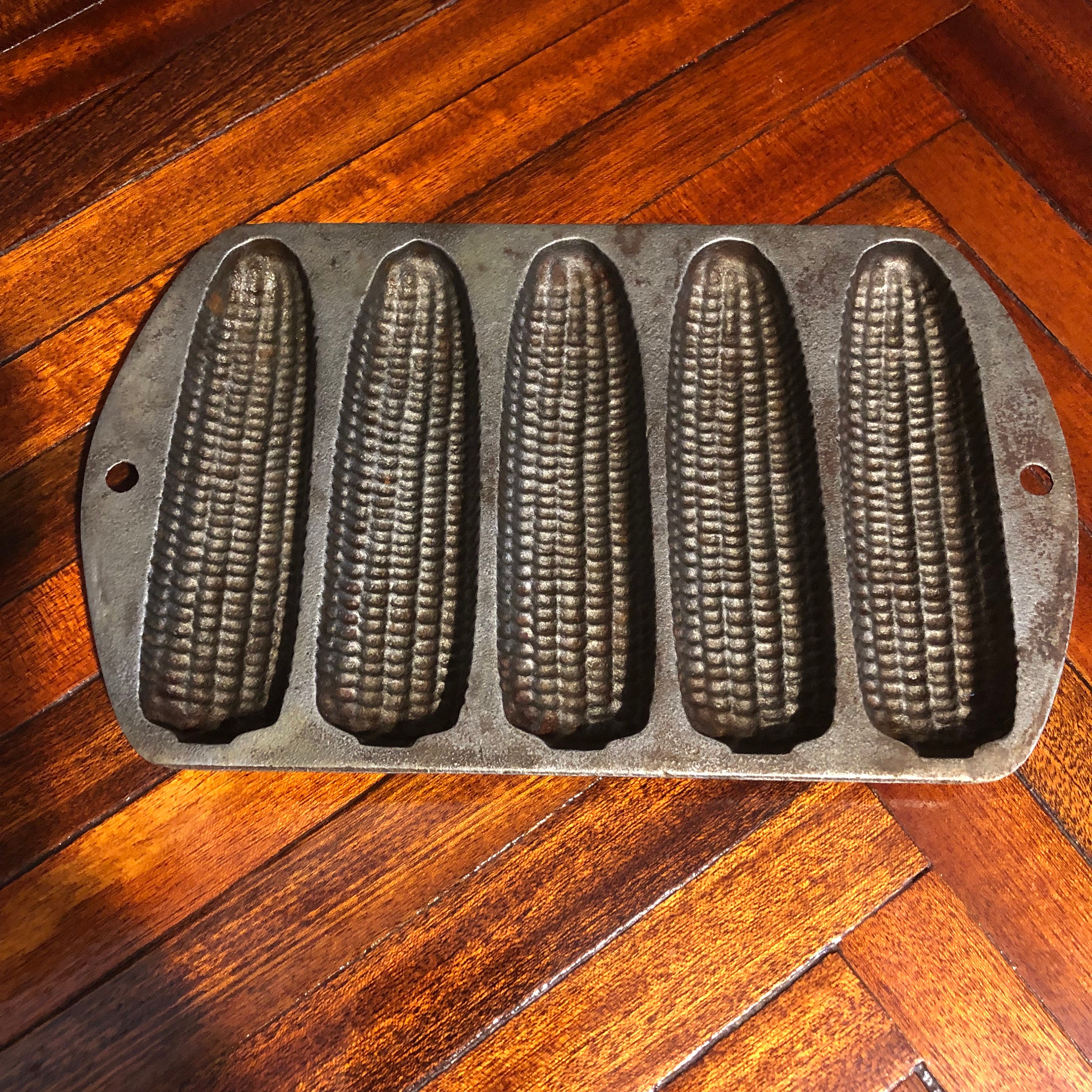 Old, rusty, cast-iron pan for baking cornbread sticks in the shape of corn  on the cob isolated against a white background Stock Photo - Alamy