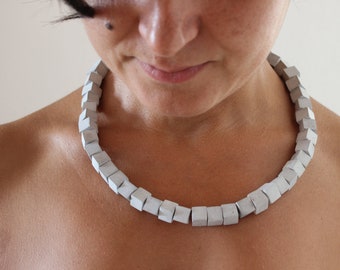 Geometric necklace with concrete cubic beads. Architecture to wear from the modern jewellery collection by ORTOGONALE