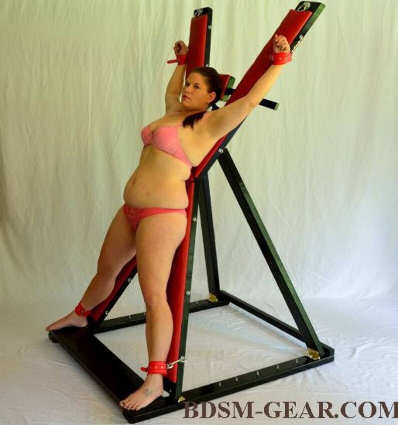 Redhead female finds herself restrained to a st andrews cross during sex games