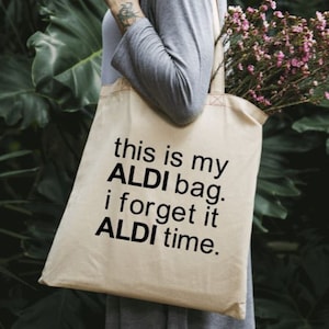 Puede incluir: Una bolsa de tela blanca con texto negro que dice "this is my ALDI bag. i forget it ALDI time."