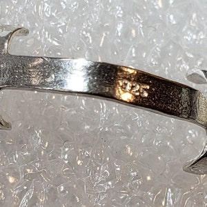 May include: A silver ring with a simple design and the inscription "925" on the inside.