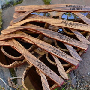 May include: A stack of wooden sunglasses with the text "KAT & ANDY 8-10-2019" engraved on each pair.
