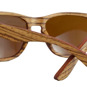 May include: Brown wood sunglasses with red accents and the word "ZONI" engraved on the side.