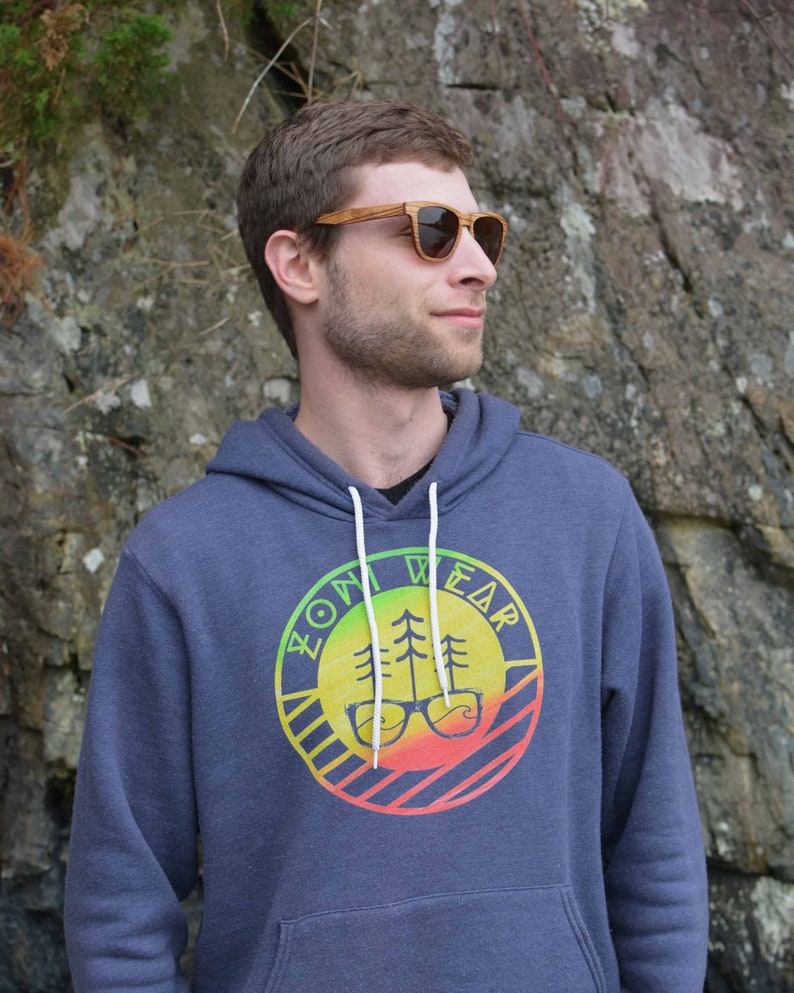 May include: A navy blue hooded sweatshirt with a colorful logo featuring a tree and glasses. The logo says "ZOM WEAR" in a circular design.