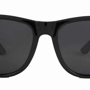 May include: Black sunglasses with a classic square frame and dark lenses.