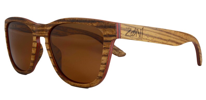 May include: Brown wood sunglasses with brown lenses and a red stripe on the side. The sunglasses have the word "ZONI" engraved on the side.