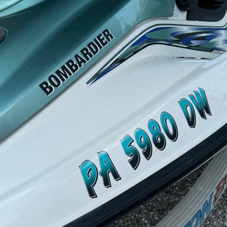 Puede incluir: Una moto acu&aacute;tica blanca y turquesa con la palabra "BOMBARDIER" en letras negras en el lateral y la matr&iacute;cula "PA 5980 DW" en letras turquesa en la parte trasera.
