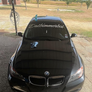 May include: A black BMW 3 series car with a custom windshield banner that reads "Datbimmerboi".