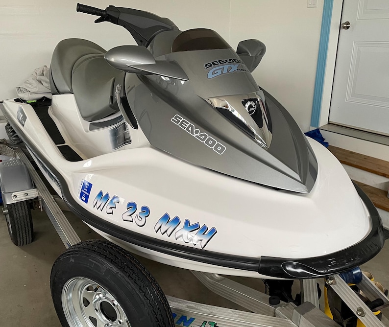 Puede incluir: Un jet ski Sea-Doo blanco y gris con ribetes negros. El jet ski tiene una pegatina que dice "Sea-Doo GTX" y "Sea-Doo". El jet ski tambi&eacute;n tiene una pegatina que dice "ME 23 MXH".