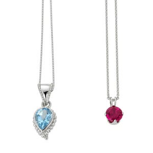 May include: Two silver necklaces on thin box chains. The left pendant features a pear-shaped light blue gemstone surrounded by small clear stones. The right pendant features a round, vibrant pink gemstone held in a simple four-prong silver setting.