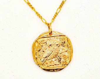May include: Gold necklace with a round pendant featuring an owl design. The pendant is detailed with a textured surface and a raised owl image.