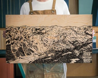 Puede incluir: Un mapa grabado en blanco y negro de la estación de esquí de Palomar Mountain en California en una placa de madera. El mapa muestra las pistas de esquí, los remontes y otras características de la estación.
