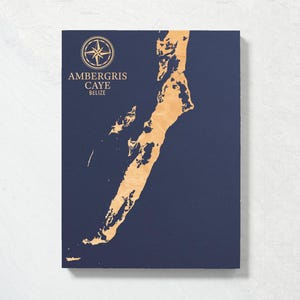 May include: A navy blue wooden map of Ambergris Caye, Belize with a compass rose and the text "Ambergris Caye Belize" in gold lettering.