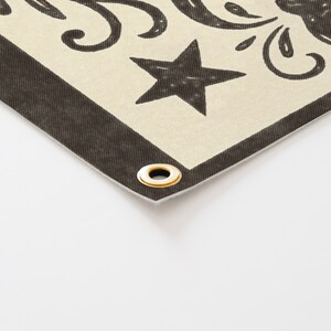 a close-up view of a decorative fabric with a black star and a gold ring on it.