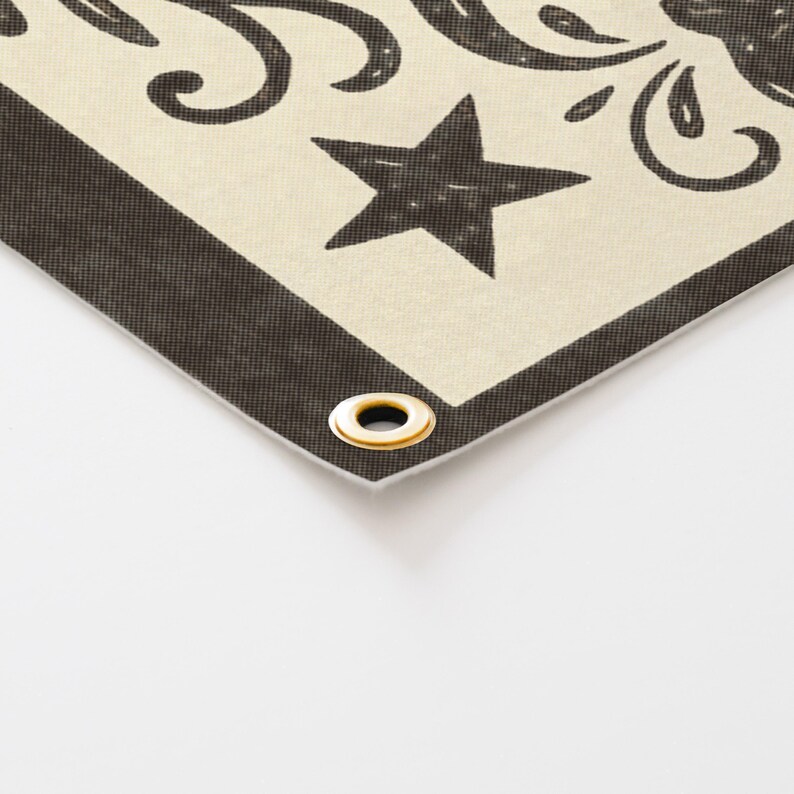 a close-up view of a decorative fabric with a black star and a gold ring on it.